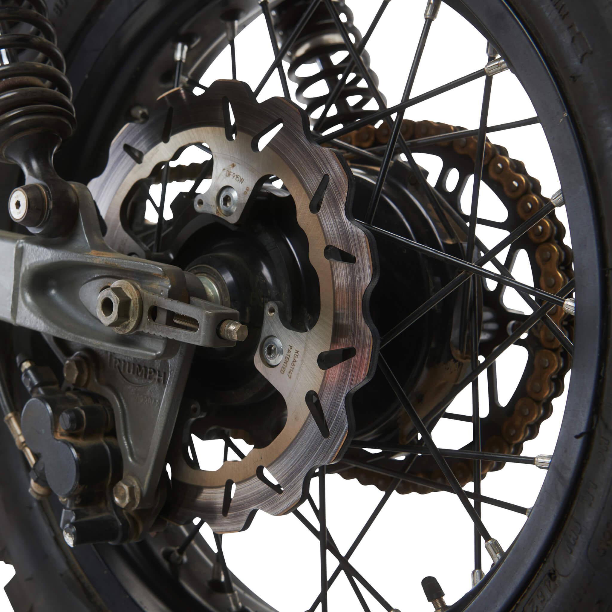 Close view of the DF915W wave rotor on a Triumph rear wheel, part number and KBA marks visible