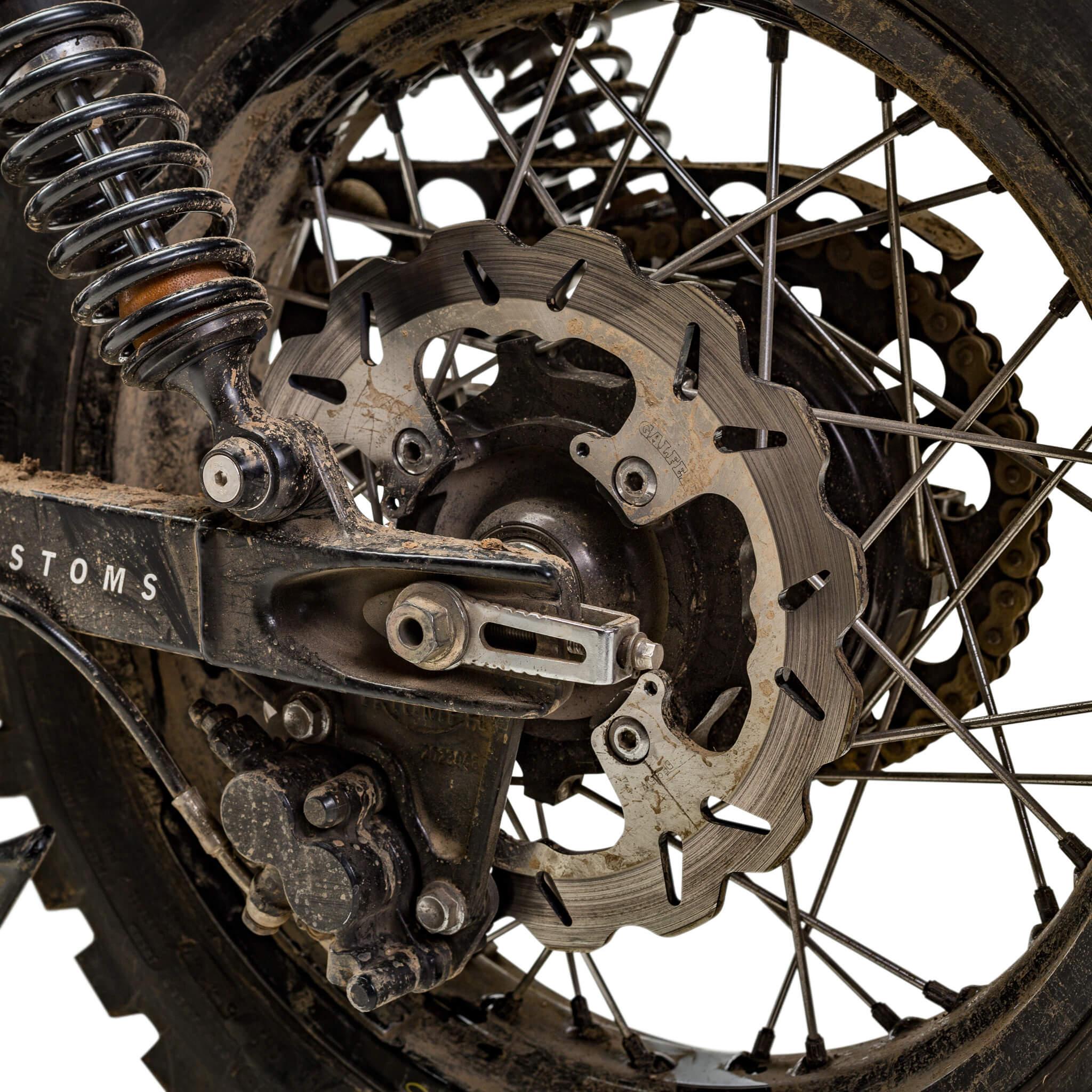 Galfer rear wave rotor on a dust covered Triumph scrambler rear wheel with gold chain